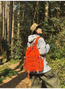 Lifestyle-Ansicht eines robusten orangefarbenen Nylon-Rucksacks für Wandern und Camping