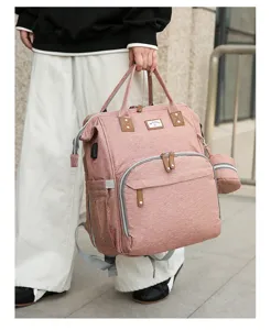Stilvoller rosa Rucksack für Mütter mit großer Kapazität im Freien in der Hand gehalten
