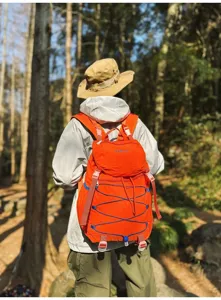 Leichter orangefarbener Wanderrucksack aus Nylon im Wald für Campingabenteuer