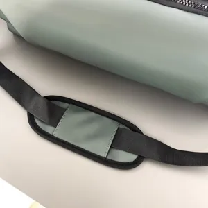 Gros plan du coussin de bandoulière de sac de sport imperméable gris-vert et de la sangle.