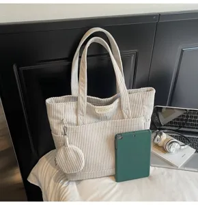 Detailed view of a stylish large capacity cream corduroy tote bag with matching coin pouch