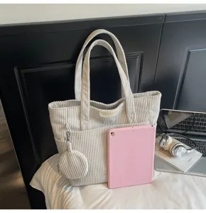 Corduroy tote bag with mini pouch shown next to a pink tablet for scale