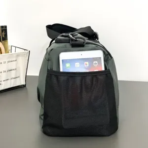 Vue détaillée du sac de sport de voyage vert foncé avec poche filet avant pour tablette.