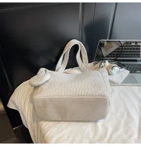 Detailed view of the large white corduroy tote bag with matching small coin purse accessory