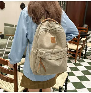 Vista posteriore di uno studente con zaino in velluto a coste beige in un bar.