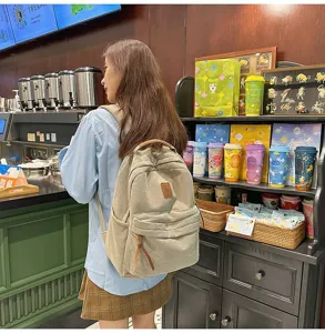 Vista dettagliata di uno zaino di velluto a coste beige indossato in un caffè casual