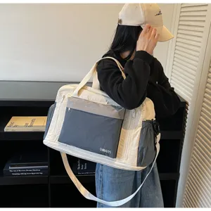 Asian model carrying a cream and charcoal large travel gym bag with long shoulder strap