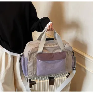 Close-up of a purple and grey travel fitness bag held over a white suitcase