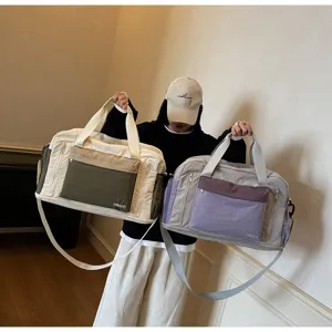 Two colorful dry-wet separation travel bags held by a model in a modern interior.