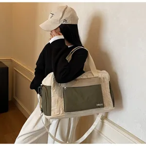 Model carrying olive green and cream color-blocked travel duffel bag for gym and sports.