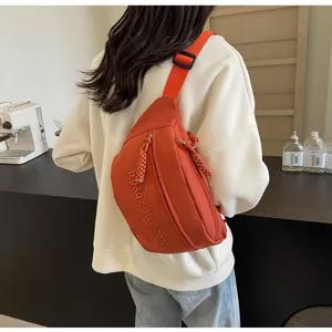 Back view of a woman wearing a vibrant orange sporty crossbody chest bag with embroidery