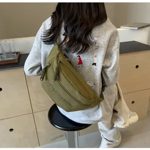 Olive green minimalist crossbody chest bag showing back strap and embroidery details