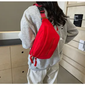 Red multi-functional crossbody chest bag shown being worn over a casual grey sweatshirt