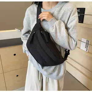 Minimalist black crossbody chest bag shown on model in a stylish lifestyle setting.