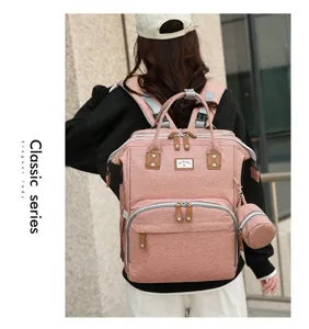 Rückansicht eines stylischen rosa Wickelrucksacks, getragen von einem Model im Freien.