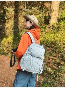 Frau trägt hellblauen Wanderrucksack im Wald, Detailaufnahme des Outdoor-Lifestyles