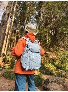 Leichter hellblauer Nylon-Wanderrucksack mit Kordelzug auf einem Waldweg genutzt
