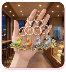 Detailed view of four colorful parrot keychains featuring rhinestone and floral accents
