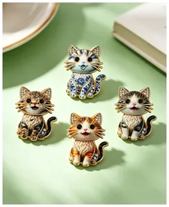 Detail view of four unique cartoon cat enamel brooches with intricate patterns and crystals.