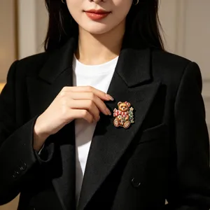 Charmante broche ours de Noël avec écharpe rouge festive épinglée sur un élégant blazer noir
