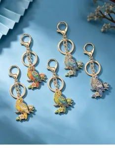 Detailed view of five colorful enamel parrot keychains with rhinestone floral branch motifs.