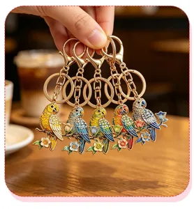 Close-up of five colorful enamel parrot keychains with intricate floral branch designs