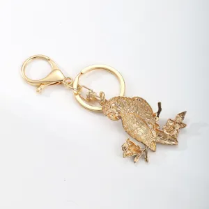 Elegant golden metallic parrot on flowery branch keychain accessory for bags and car keys