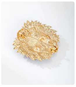Detailed view of the back of a gold-tone floral skull brooch showing the pin mechanism