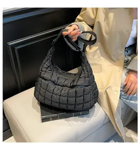 Minimalist black quilted puffer cloud bag with pleated texture and adjustable strap