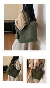 Detailed view of green corduroy tote bag with small matching pouch on shoulder.