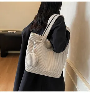 Large capacity off-white corduroy tote bag with matching round pouch shown on model