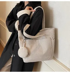 Detailed macro view of cream corduroy tote bag with a matching mini coin purse charm