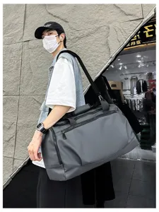 Vue détaillée d'un grand sac de sport gris, montrant un tissu résistant et une sangle solide.