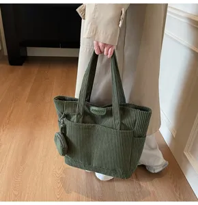 Detailed view of large olive green corduroy tote bag featuring a matching round coin pouch