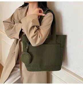 Detailed shot of green corduroy tote bag with matching small round coin pouch attachment.