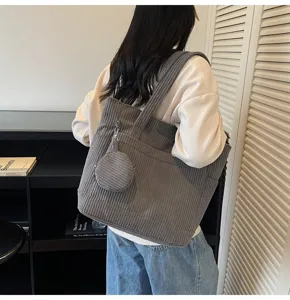 Grey corduroy tote bag with large capacity shown on model shoulder for daily use