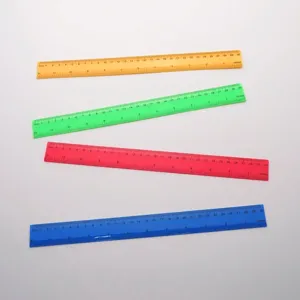 Gros plan montrant un jeu de quatre règles en plastique de 30 cm en jaune, vert, rouge et bleu