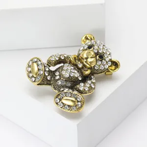 Vista detallada de un brillante broche de oso dorado adornado con pedrería clara.
