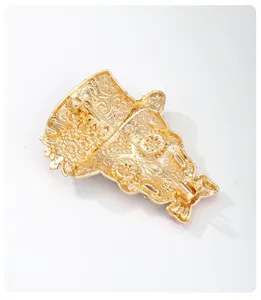 Detailed back view of a vintage gold Day of the Dead skull brooch with safety pin.