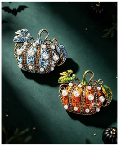 Vue détaillée des broches citrouille d'Halloween vintage avec perles et strass en deux tons.