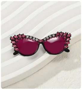 Primer plano de un broche de gafas de sol con diamantes de imitación rosas y magenta.