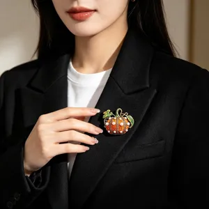 Broche citrouille Halloween vintage avec perles et strass sur le revers d'un blazer noir.