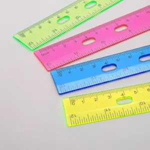 Primer plano de cuatro reglas de plástico traslúcido de colores con escalas métricas