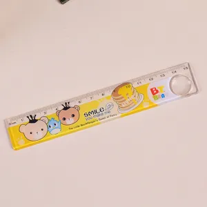 Gros plan d'une règle en plastique avec dessins animés, échelle 15cm et loupe intégrée