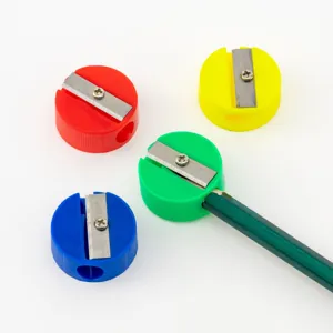 Mini round pencil sharpeners in red, blue, yellow, and green colors on white backdrop