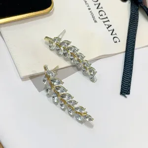 Detailed macro shot of sparkling wheat ear crawler earrings with clear marquise cut stones