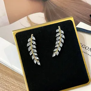 Macro view of sparkling wheat ear earrings with marquise-cut stones in gold finish