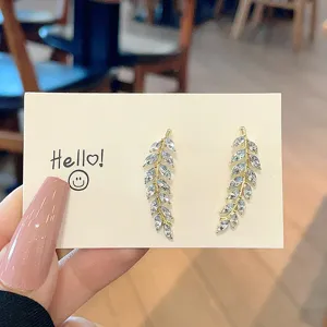Close-up of sparkling wheat leaf ear studs with shiny marquise-cut crystals