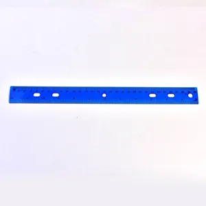 Gros plan d'une règle en plastique bleu translucide de 30 cm avec 6 trous circulaires évidés