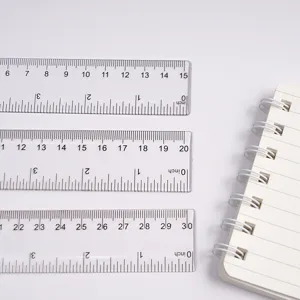 Close-up of transparent plastic rulers with clear metric and inch scales for precise drawing.